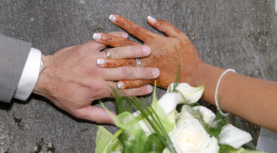 手和戒指放在婚礼花束上背景图片