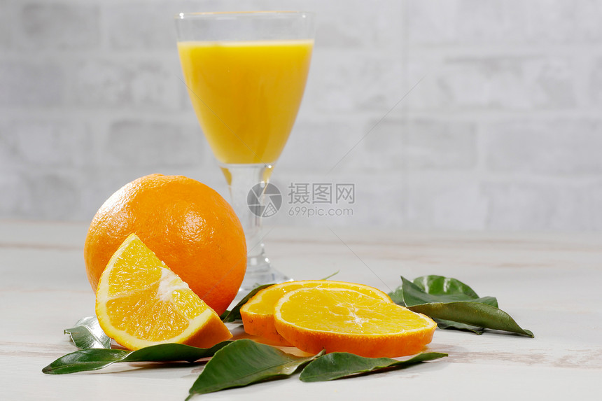 白木桌上的橙子和汁杯图片