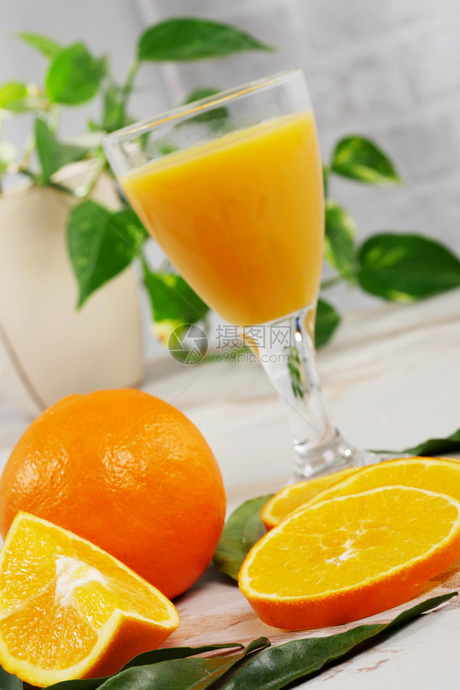 白木桌上的橙子和汁杯图片