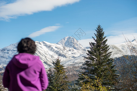 一个穿紫色衣服的女人看着雪山图片