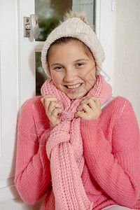 带着粉红色毛衣和冬帽的笑着少女图片