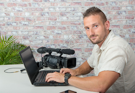 配备膝上型计算机和专业摄像的男录编辑图片