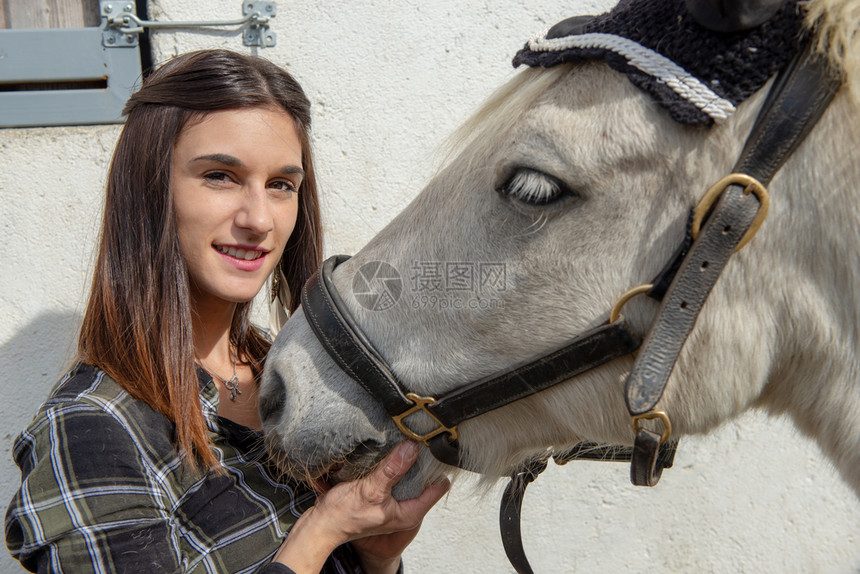 一位美丽的年轻女子骑着白马的肖像图片