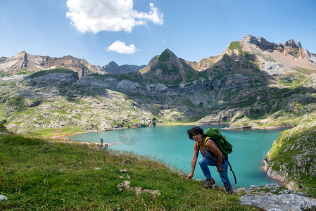 一名妇女登山徒攀爬坡Estaens湖背景图片
