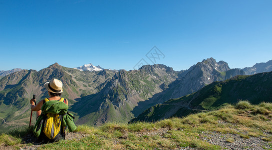 一个远足的女人休息一会儿看着山背景图片