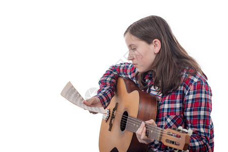 年轻女孩学会弹吉他孤立在白色背景上图片