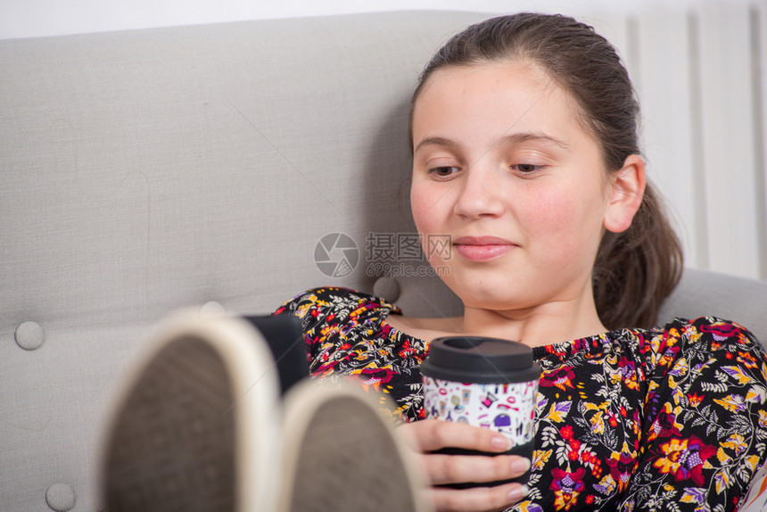 一个十几岁的女孩在沙发里放松图片