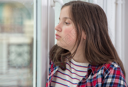 窗户旁边的一位青春少女背景图片