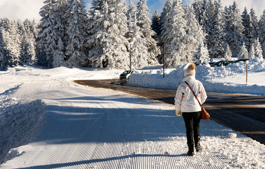一个女人在冬天的雪中行走图片