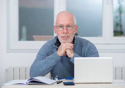 一个在办公室使用笔记本电脑的中年男子图片