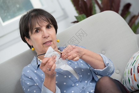 在沙发上洗杯子的成年黑发女人背景图片