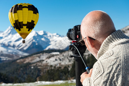 摄影师在山顶上拍摄热气球图片