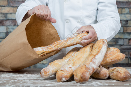 a面包师持有传统法国面包图片