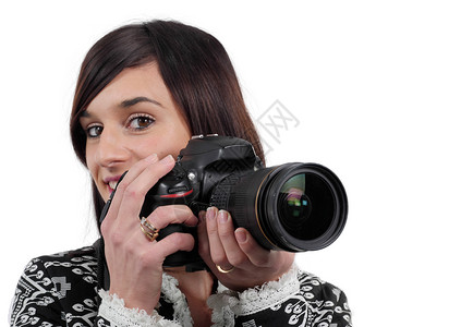 年轻黑发女人拿着白色背景孤立的SLR相机图片