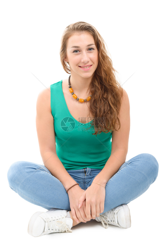 一个微笑着的女士穿绿色的散装智能服坐在横跨双腿的上图片