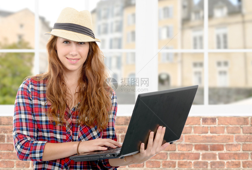 一个带着微笑的面容拿着笔记本电脑的年轻女子图片