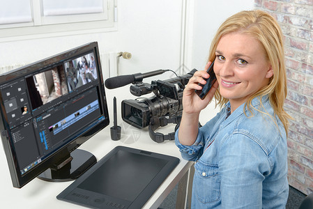 使用计算机编辑视频的年轻金发女设计师图片