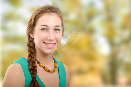 穿着绿色散装智能服的年轻微笑着的女士图片