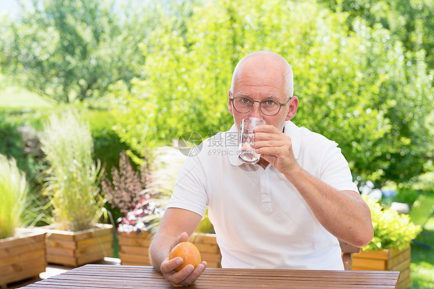 在阳台上喝杯水的老人图片