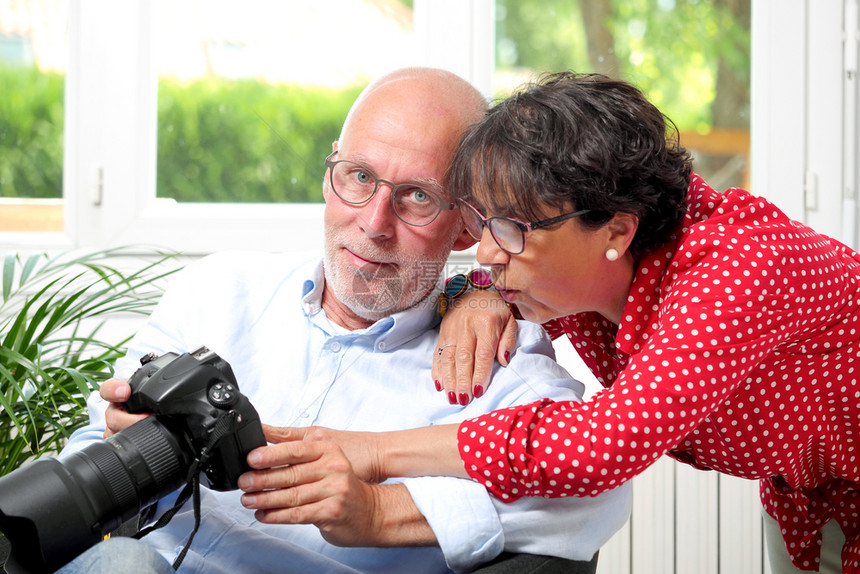 一对年长夫妇在看镜头屏幕上的照片图片