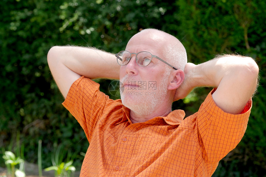 一位成熟男子在花园里放松的肖像图片