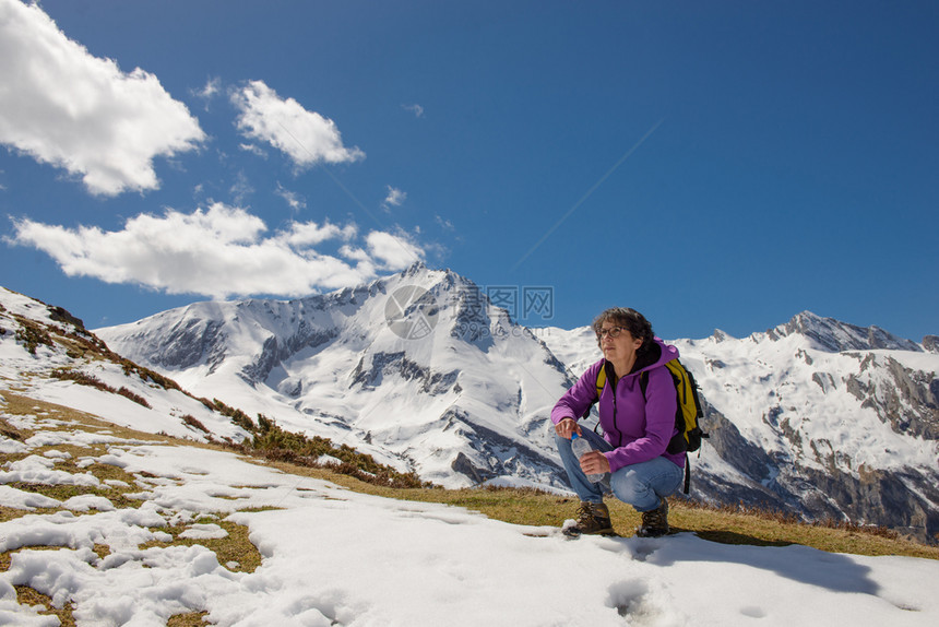 一位在法国比利牛斯的女远足者春天带着雪苏勒尔山图片
