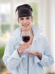 年轻黑发女人喝一杯红酒图片