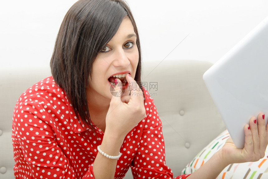 一个年轻的黑发美女在沙上吃巧克力图片