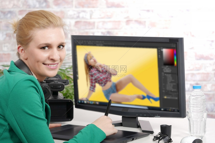 使用图形平板片进行视频编辑的年轻金发女设计师图片