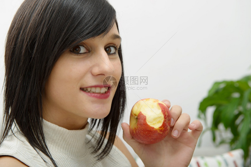 年轻妇女在家里吃苹果图片