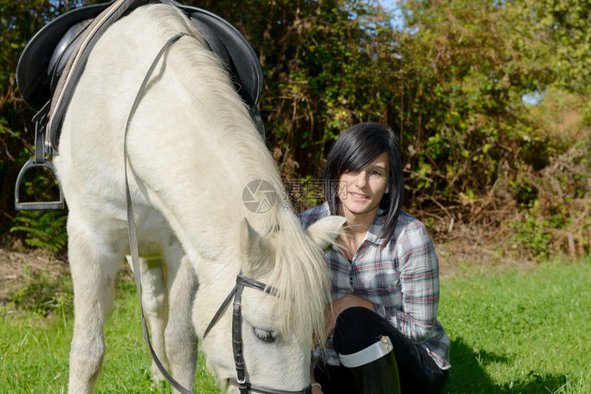 白马骑着的漂亮黑褐色年轻女子图片