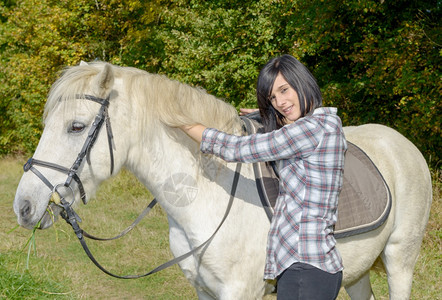 白马骑着的漂亮年轻黑发美女高清图片