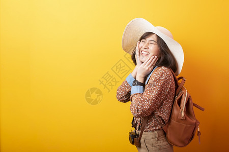 黄背景的亚洲快乐旅游女图片
