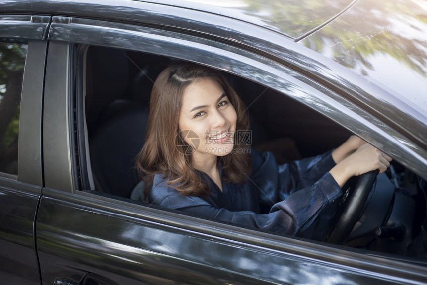 美丽的女士正在驾驶她的车图片