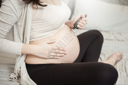 孕妇腹部涂抹乳霜的特写镜头图片