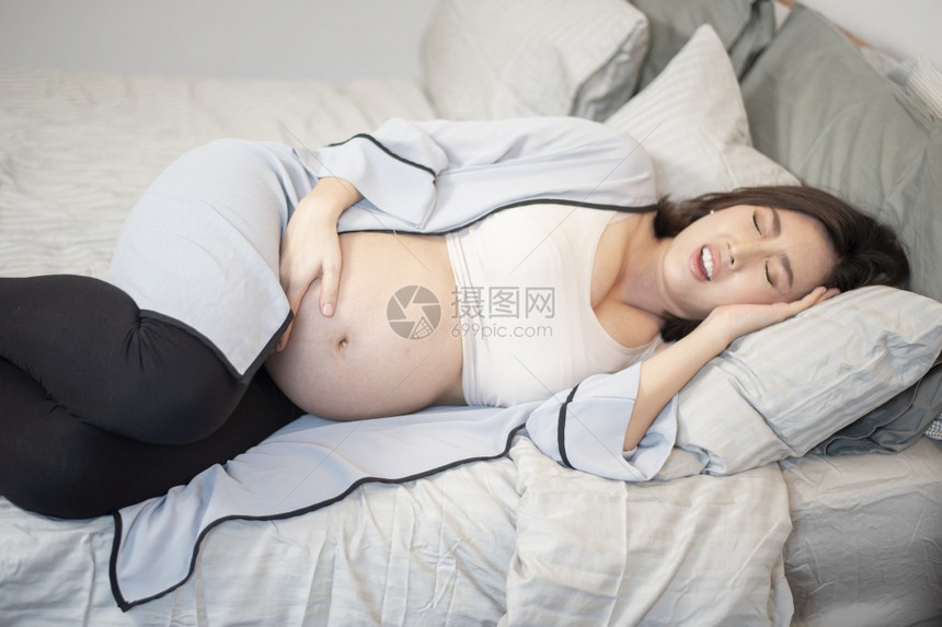 美丽的亚洲孕妇睡在床上图片