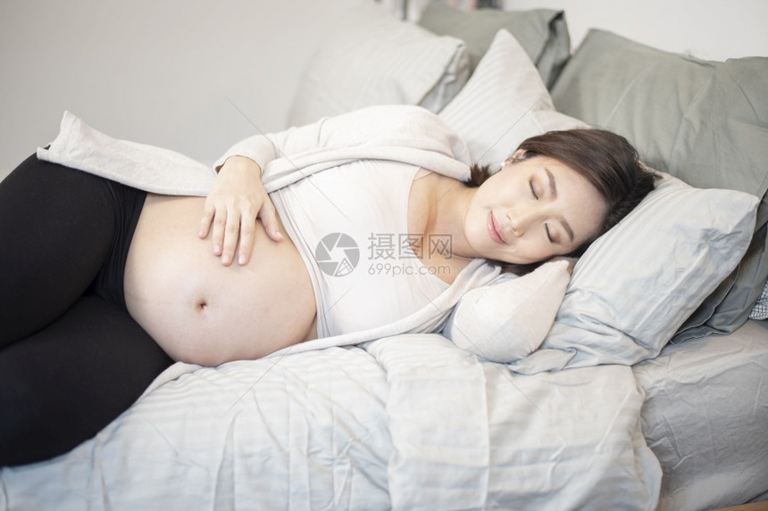 美丽的亚洲孕妇睡在床上图片