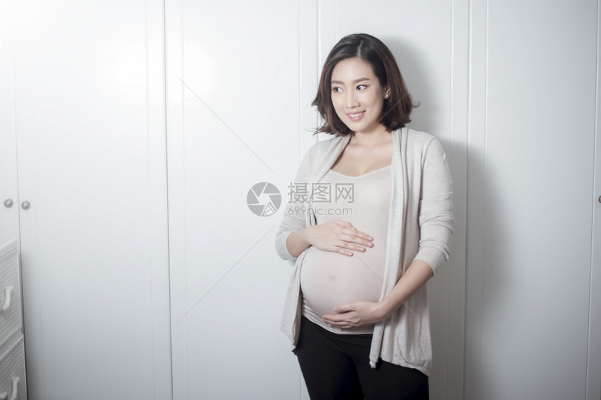 美丽的亚洲孕妇抚摸肚子图片
