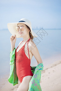 穿着红泳衣的美女肖像在沙滩上放松图片