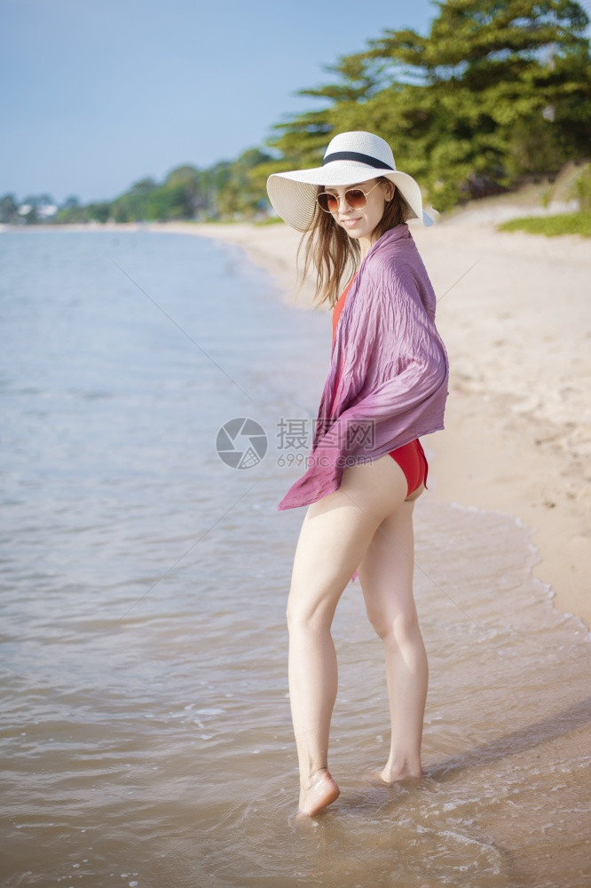 穿着红泳衣的美女肖像在沙滩上放松图片