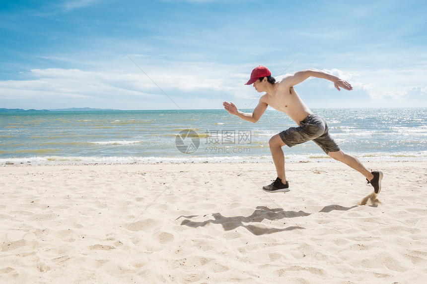 肌肉男在沙滩上奔跑图片