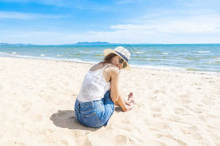 美丽的女人坐在沙滩上图片