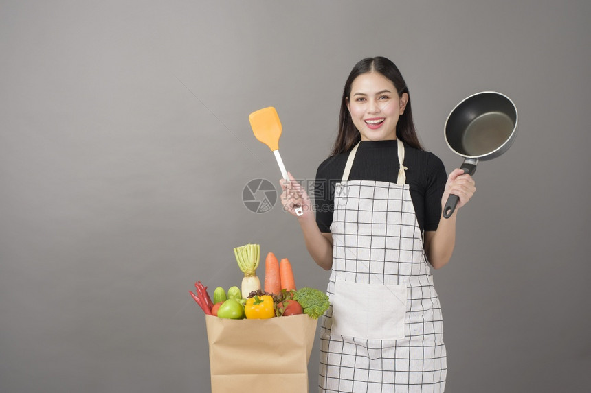 快乐的女子正在准备健康的食物做饭图片