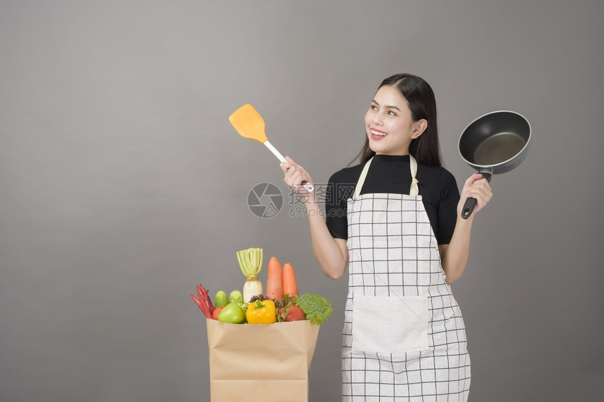 快乐的女子正在准备健康的食物做饭图片