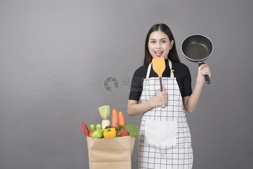 快乐的女子正在准备健康的食物做饭图片