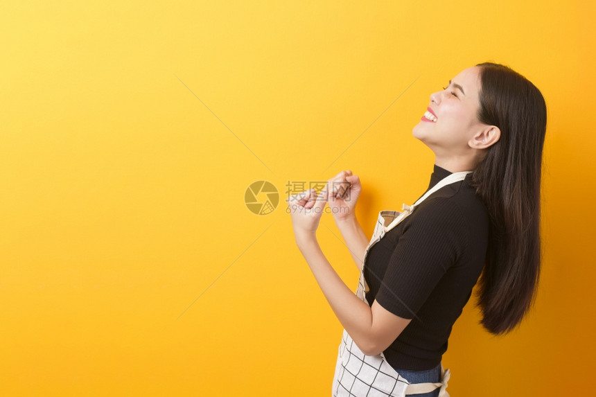 黄色背景的女厨师快乐肖像图片