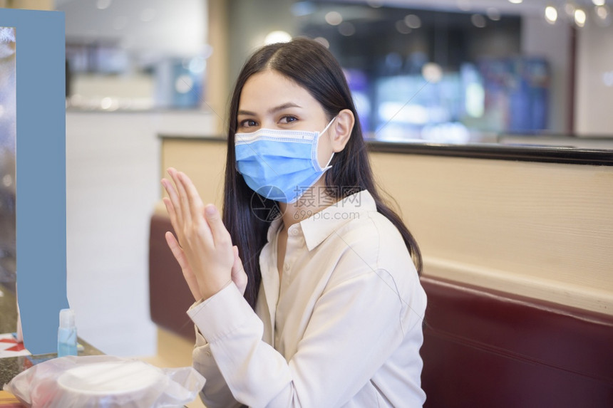 由于科罗纳大流行女在餐厅吃着社会迷魂药而新冠大流行图片