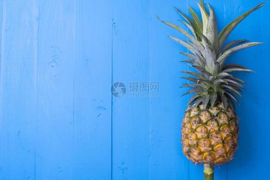 蓝木板桌上的菠萝图片
