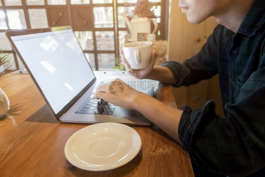 在咖啡店用电脑工作的关紧的年轻人图片
