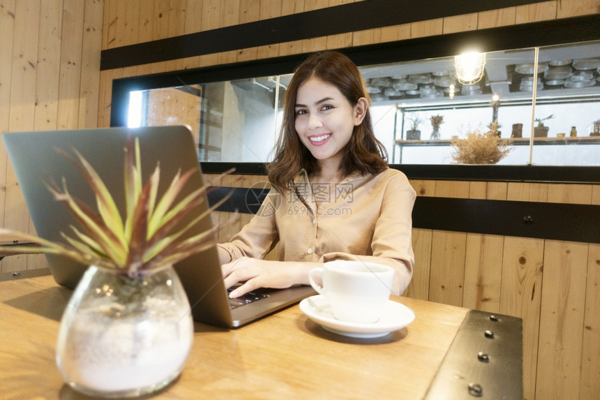 美丽的女商人在咖啡店用笔记本电脑工作图片